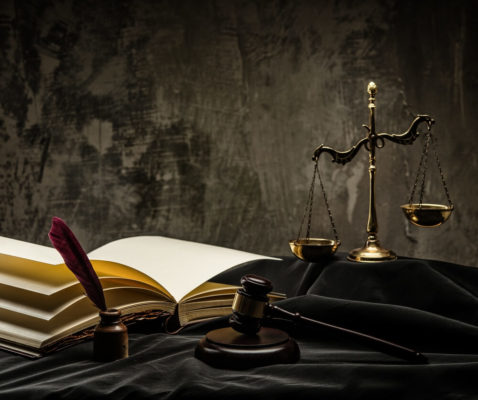 image of legal scales and notebook on a table resembling court