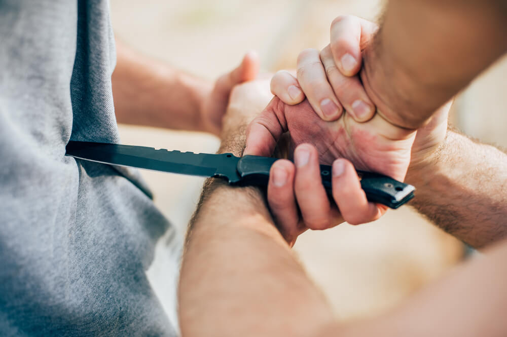 man assaulting stranger with knife