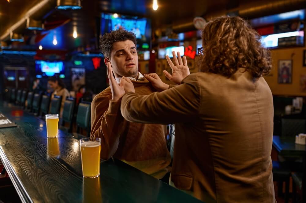 Two adults fighting at sport bar counter